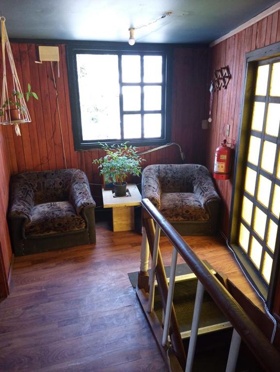a living room with two couches and a staircase at Pensión San Andrés in Concepción