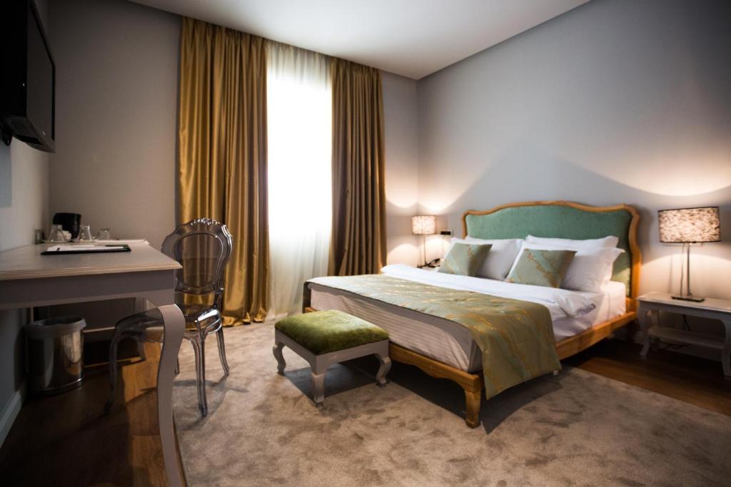 a hotel room with a bed and a desk and a window at Classic Hotel in Tirana