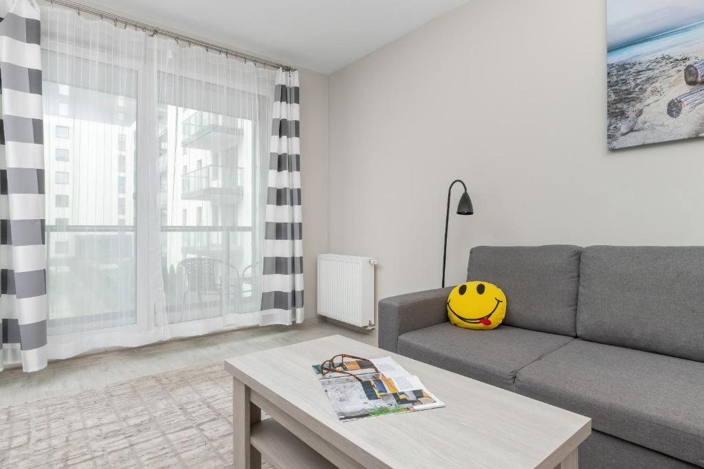 a living room with a couch and a table at Harmonia Oliwska 25 Apartment with Balcony by Renters in Gdańsk