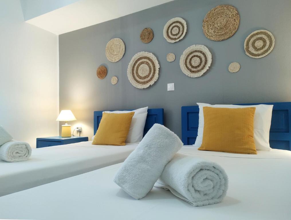 dwa łóżka w sypialni z kapeluszami na ścianie w obiekcie Summer Dream Cottage, 2BR, Beautiful sea view w mieście Mochlos