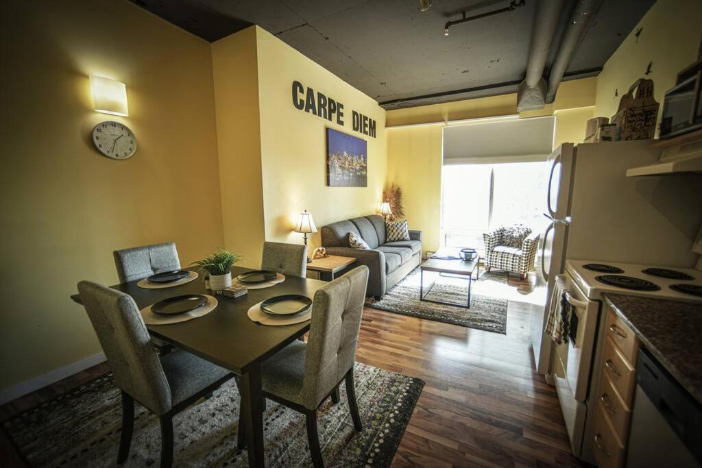a living room with a table and a kitchen with a couch at 2 Full Beds, Rogers Place Downtown Central, Memorable 1 Bedroom Condo in Edmonton