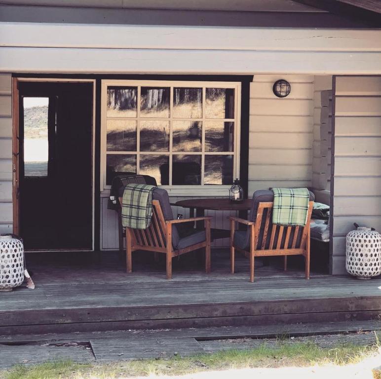 a porch of a house with two chairs and a table at Yngsjö in Yngsjö