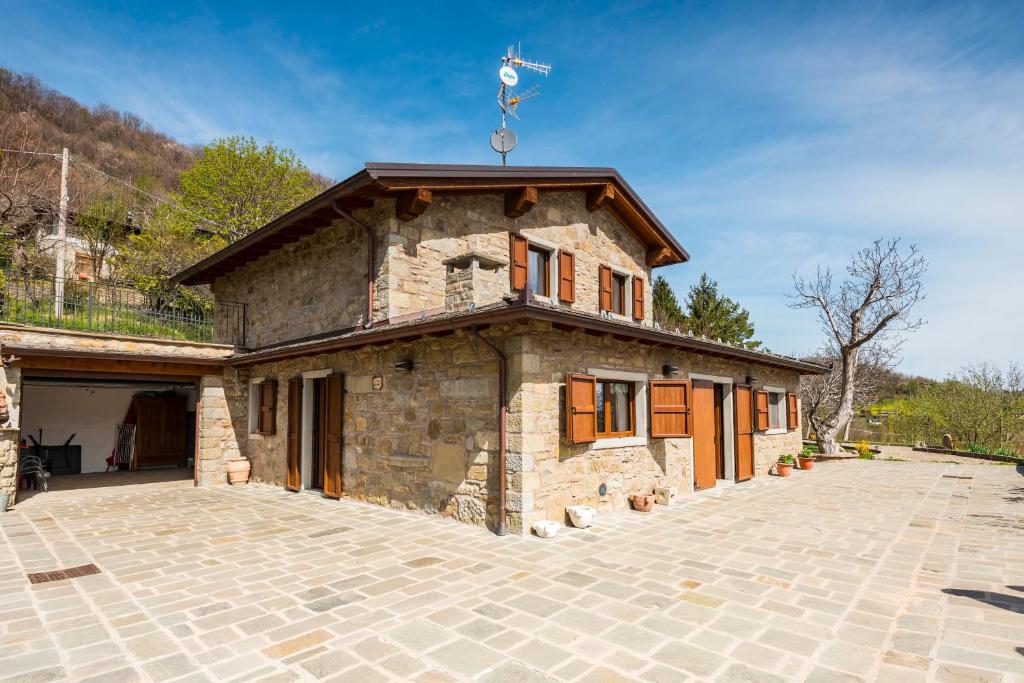 une maison en pierre avec une grande allée en face de celle-ci dans l'établissement Fanano - Panoramic Villa by Alterego, à Fanano