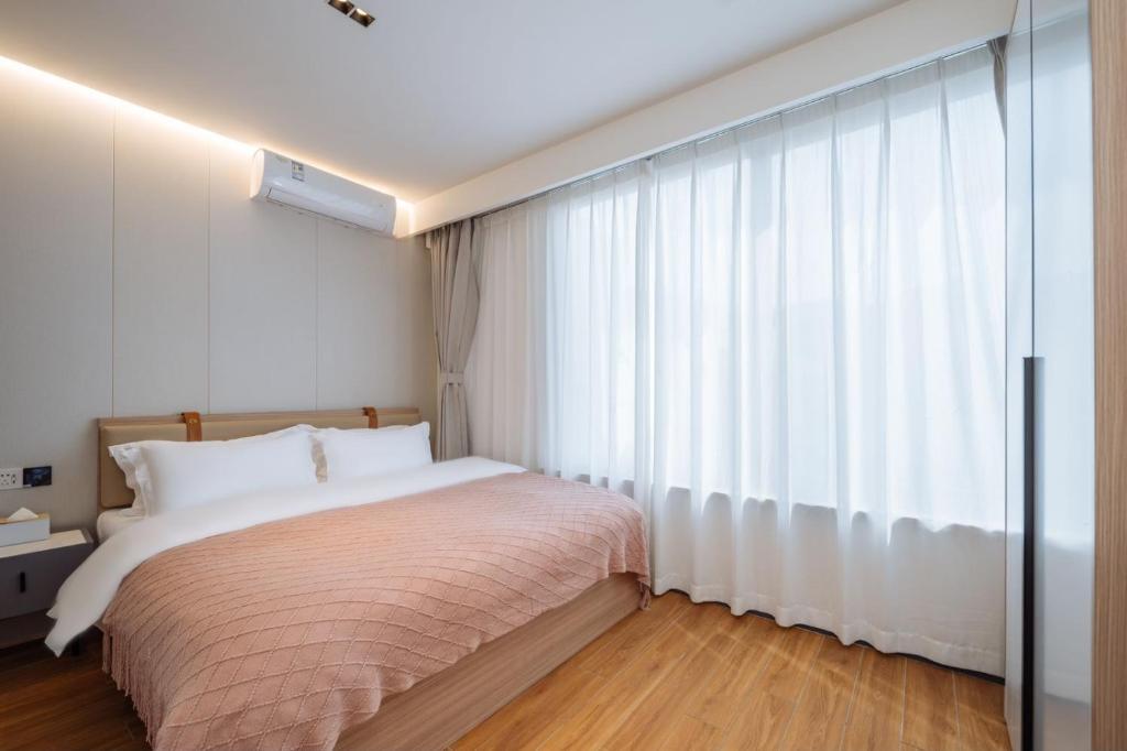 Postel nebo postele na pokoji v ubytování 上海客堂涧酒店宝山路地铁站店