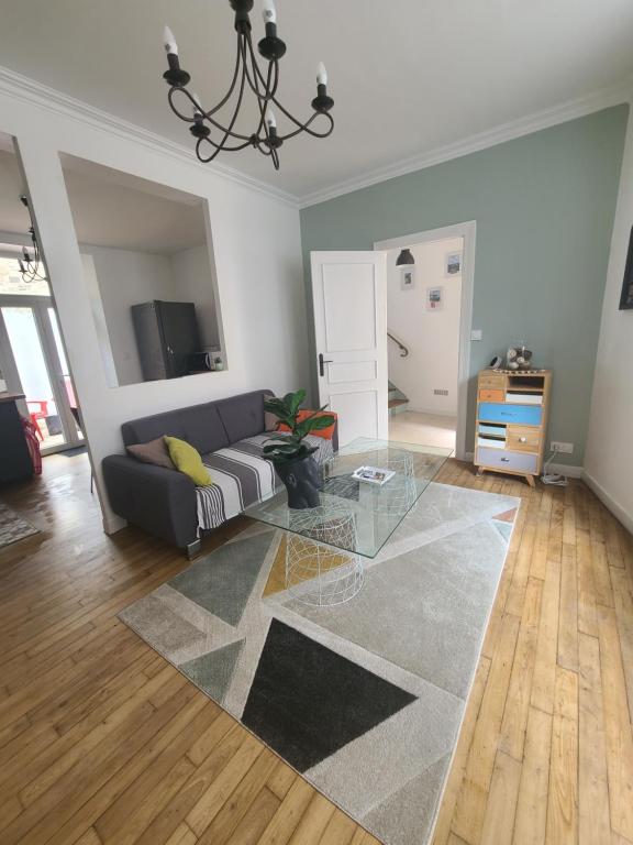 a living room with a couch and a glass table at MARCELINE in Lannion