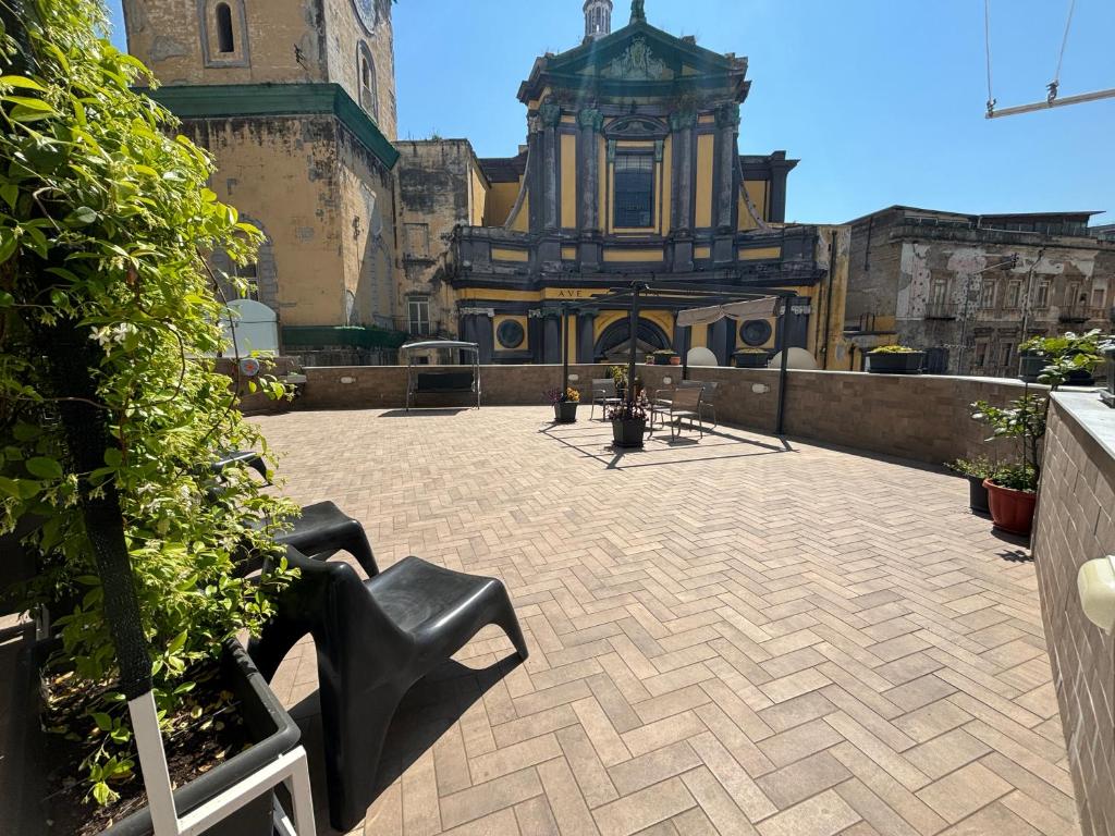un patio con un edificio con una torre de reloj en Terrazza Annunziata, en Nápoles
