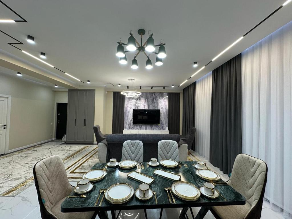 una sala da pranzo con tavolo e sedie di Жк Керуен Сарай 2 a Türkistan