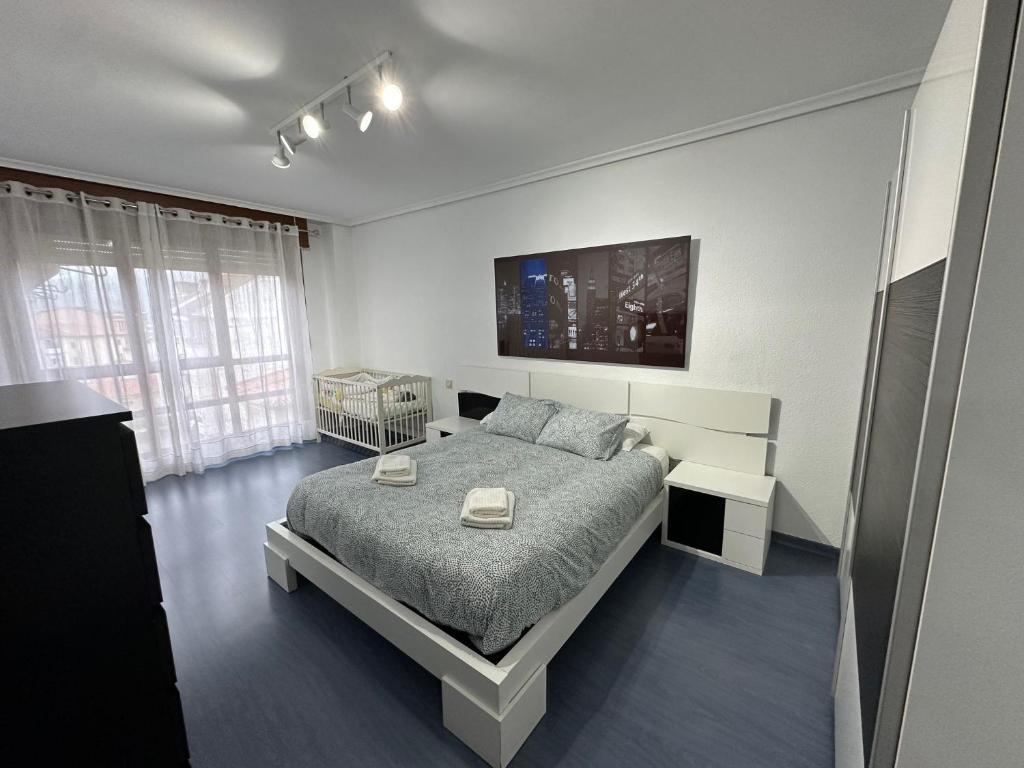 1 dormitorio blanco con 1 cama y TV en El pisuco en Sarón