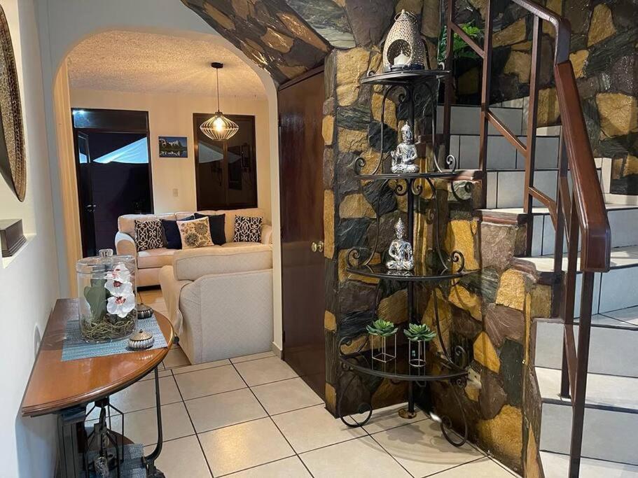 ein Wohnzimmer mit einer Steinmauer in der Unterkunft Casa en Residencial Privado Lomas de San Francisco in San Salvador
