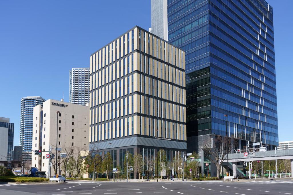 東京的住宿－东京普乐美雅凯宾总统酒店，一座高大的玻璃建筑,在城市里设有停车场