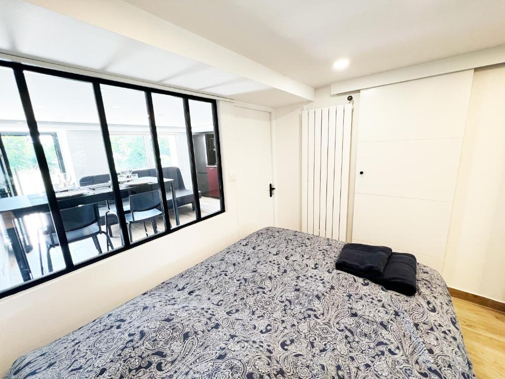 1 dormitorio con cama y ventana grande en 2 pièces cosy à 15 min de Paris, en Athis-Mons