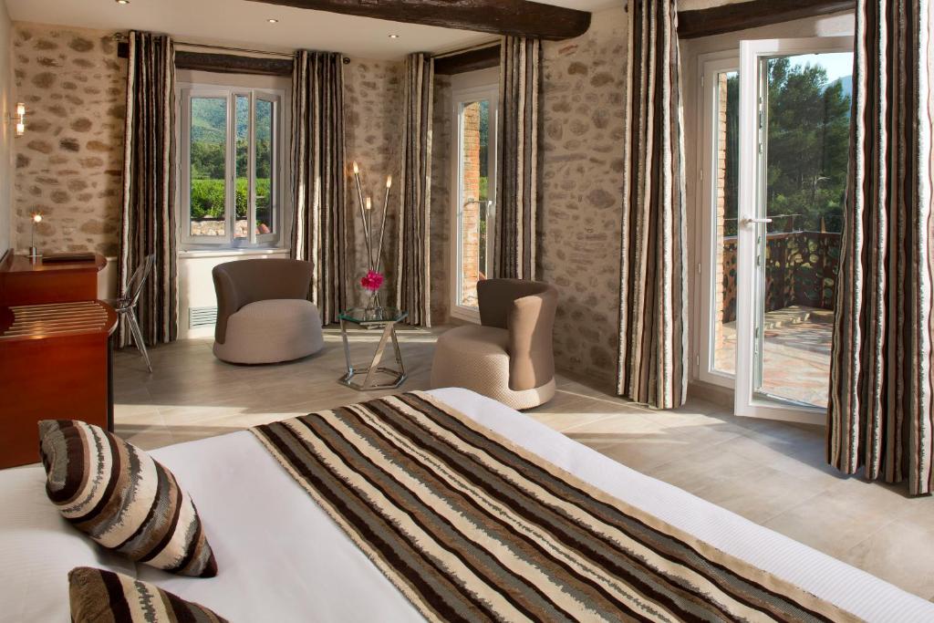 1 dormitorio con 1 cama grande y ventanas grandes en Auberge Du Roua en Argelès-sur-Mer