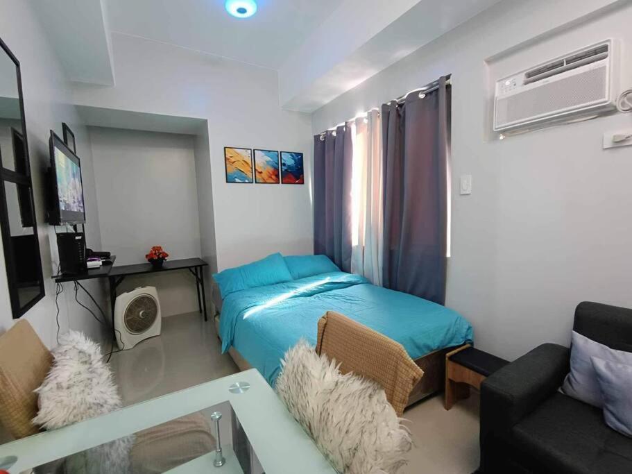 Habitación pequeña con cama y sofá en #77-2 Fern Residences Tower 5-39, en Manila