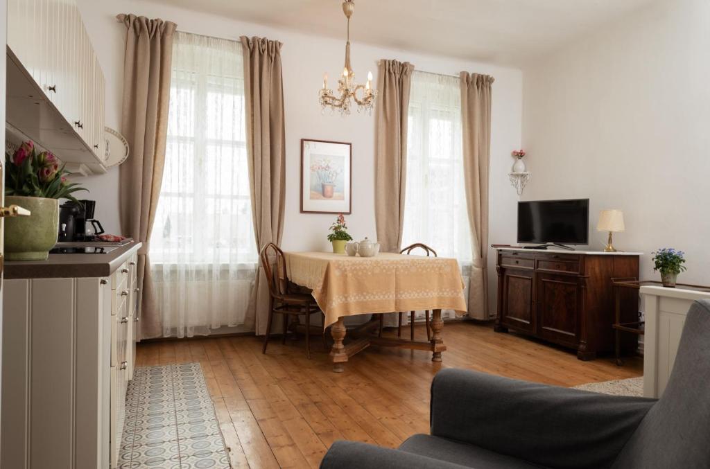 ein Wohnzimmer mit einem Tisch und einem TV in der Unterkunft Bioweingut Hauerhof 99 -apartment 4 in Klosterneuburg