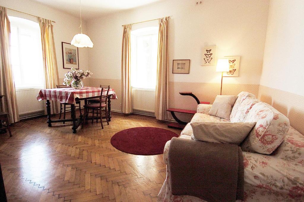 ein Wohnzimmer mit einem Sofa und einem Tisch in der Unterkunft Bioweingut Hauerhof 99 -apartment 3 in Klosterneuburg