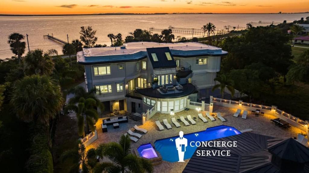 an aerial view of a house with a conference service sign on it at 9000 SF Waterfront Mansion Pool Boat Dock Theater in Fort Pierce