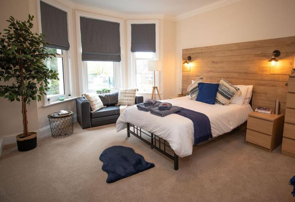 a bedroom with a large bed and a couch at Treetop View Getaway in Eastbourne in Eastbourne