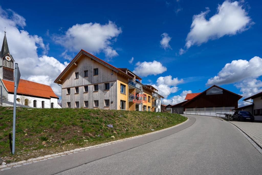 a building on top of a hill next to a street at Fewo Marca in Oy-Mittelberg