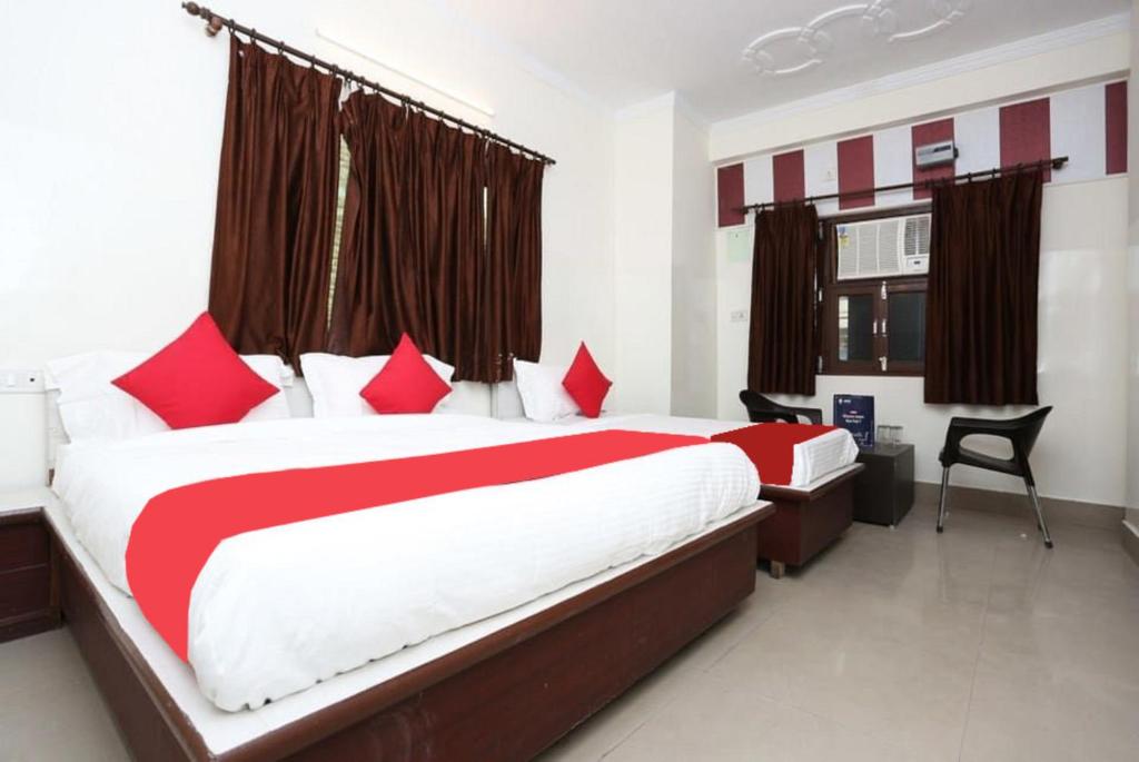 a bedroom with a large bed with red and white pillows at Goroomgo Shiva Palace Haridwar Near Railway Station - Excellent Customer Service - Best Seller in Haridwār