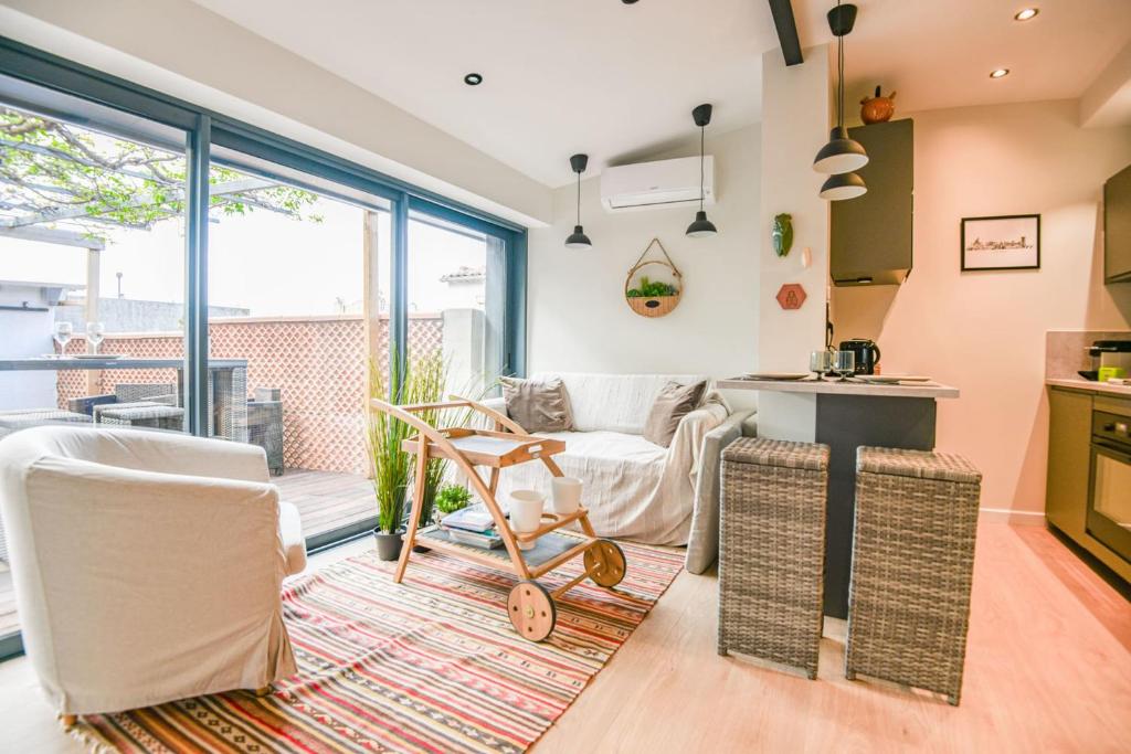 un salon avec deux chaises et une table dans l'établissement La Terrasse Ricard - Belle maison 1 ch avec clim, à Marseille