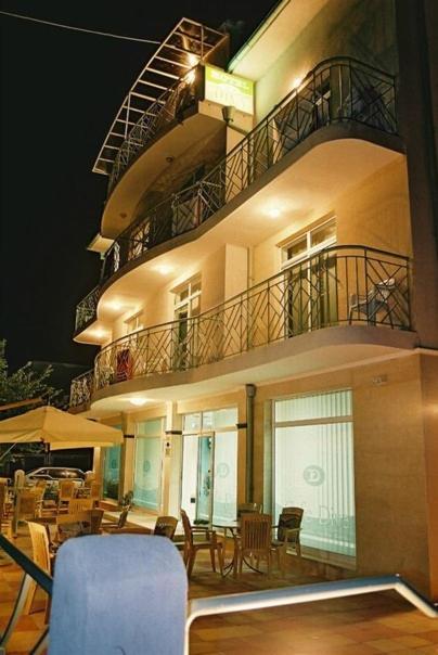 a building with a balcony with a table and chairs at Hotel Diva in Ravda