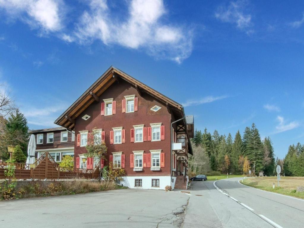 a large brown house with a gambrel roof at Property in Sibratsgfäll in Sibratsgfäll