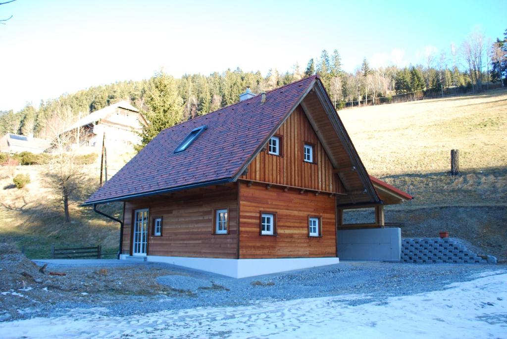 een groot houten huis met een gambrel dak bij Ferienhaus Schirgi in Sankt Kathrein am Offenegg