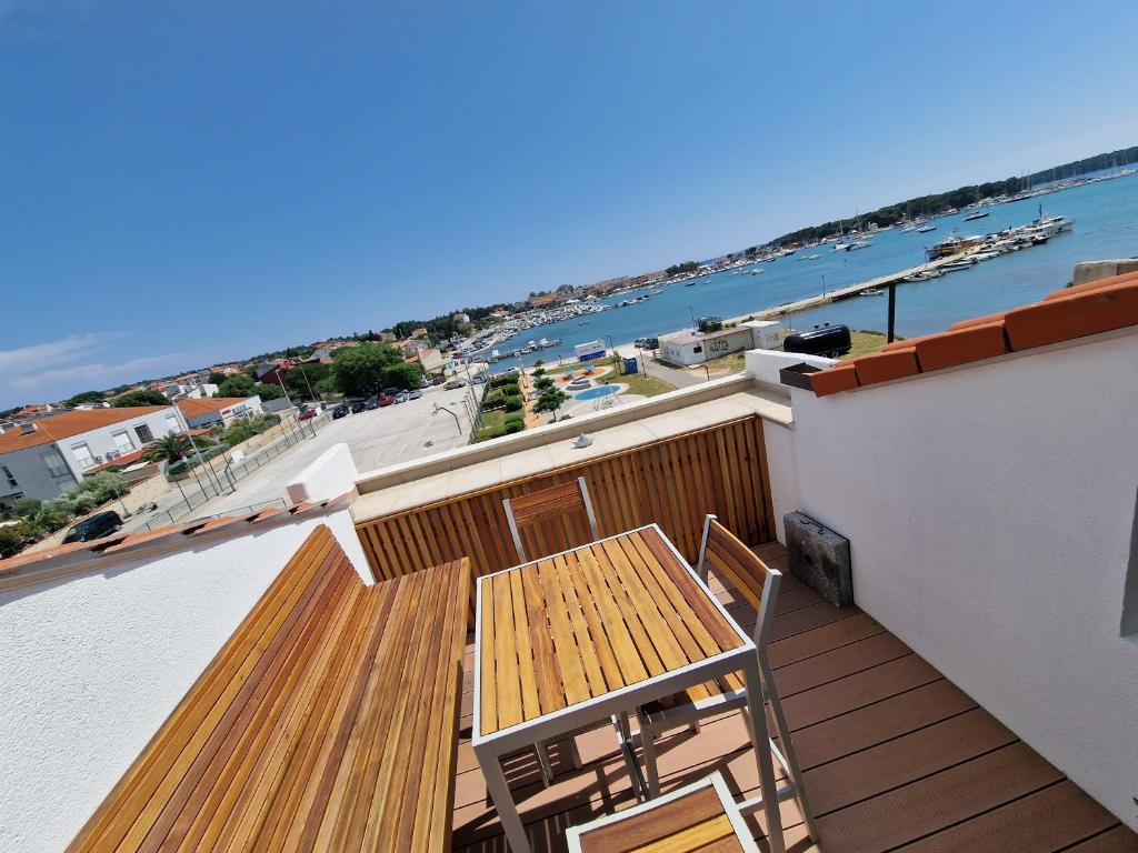 a balcony with a wooden table and chairs and the ocean at Armani Apartment Medulin in Medulin