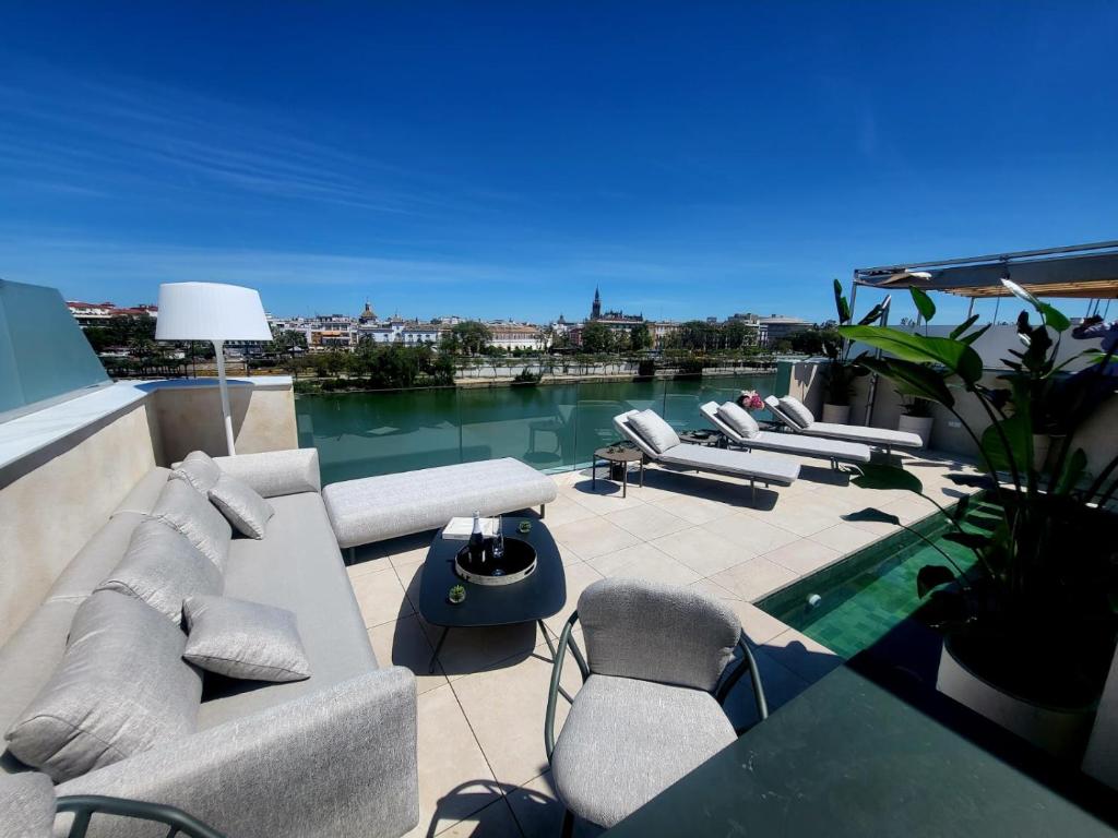 a patio with couches and chairs on a roof at CasaKary in Seville