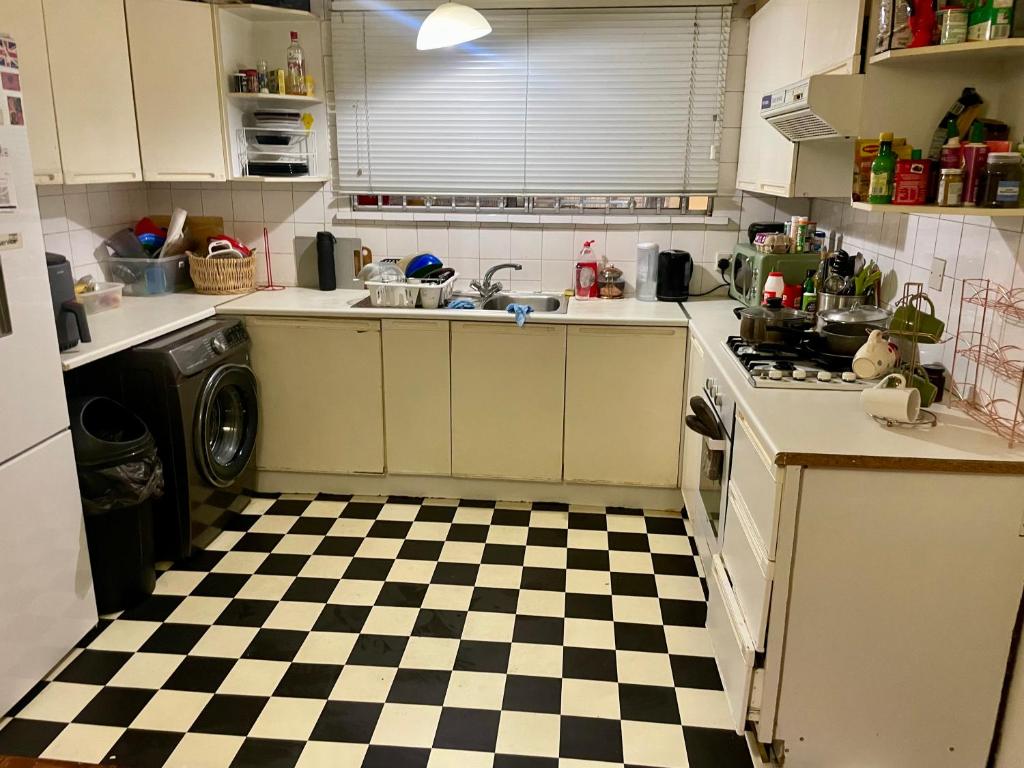 a kitchen with a black and white checkered floor at Heart of West London in London