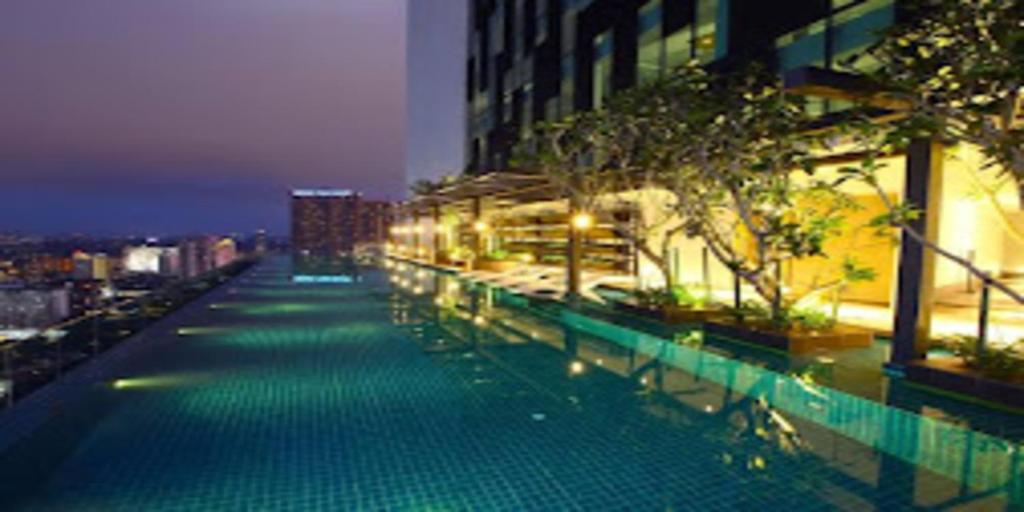 a swimming pool in a city at night at Tribeca Serviced Hotel by Millennium in Kuala Lumpur