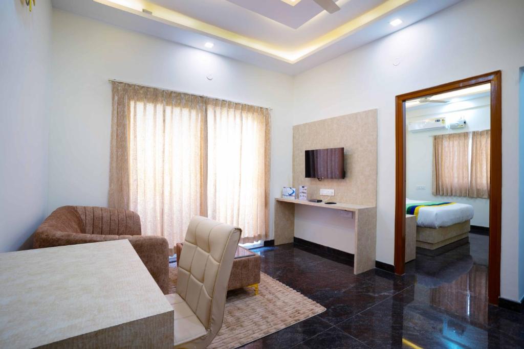 una habitación de hotel con una mesa y un dormitorio en Treebo Trend Galaxy Kings Suites, en Bangalore