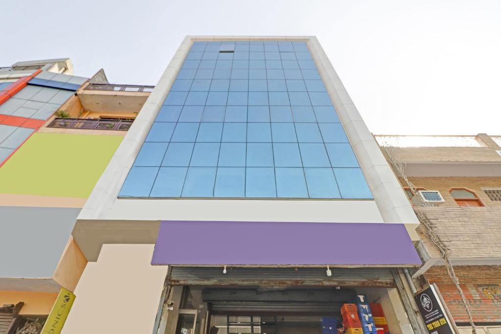 ein großes Gebäude mit einem lila Schild davor in der Unterkunft OYO Town Plaza in Neu-Delhi