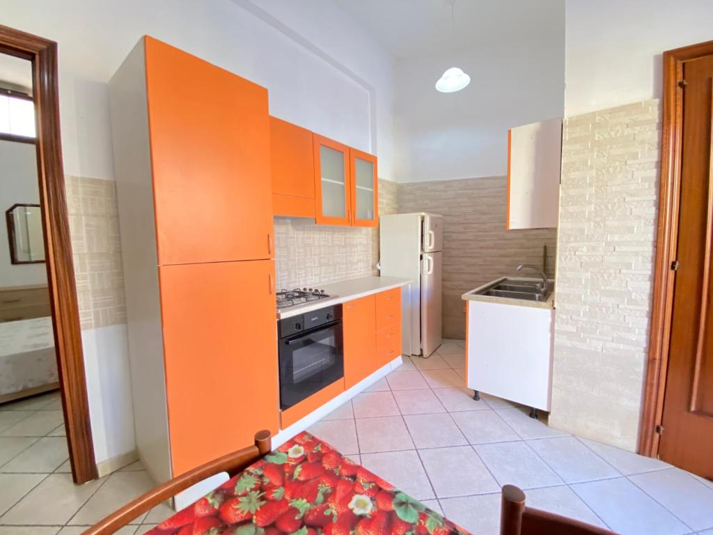 een keuken met oranje kasten en een witte koelkast bij Small House Gallipoli in Gallipoli