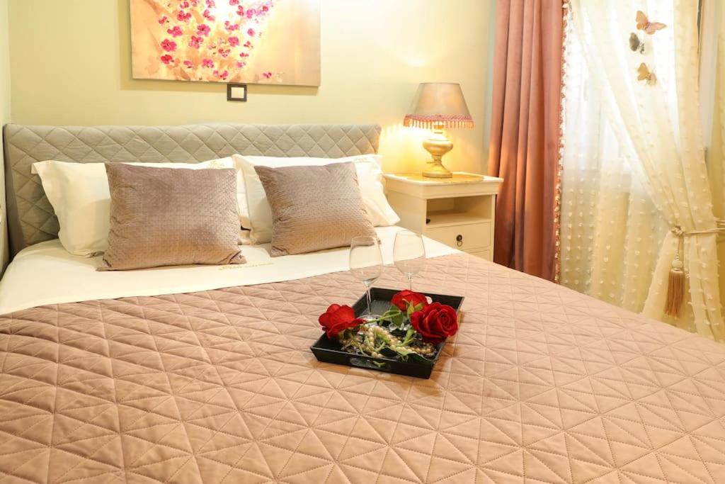 a tray of roses on a bed in a bedroom at IRIS COZY HOUSE με ανεξάρτητη είσοδο in Volos