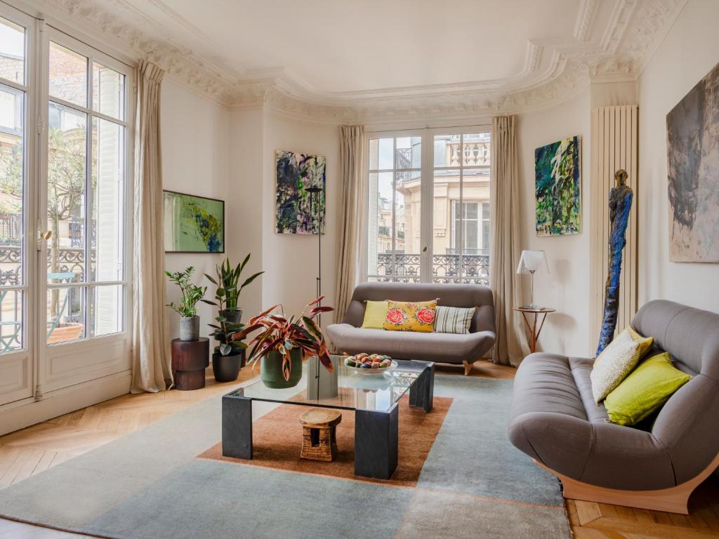 un salon avec un canapé et une table dans l'établissement Paris Eugène Design Residence, à Paris