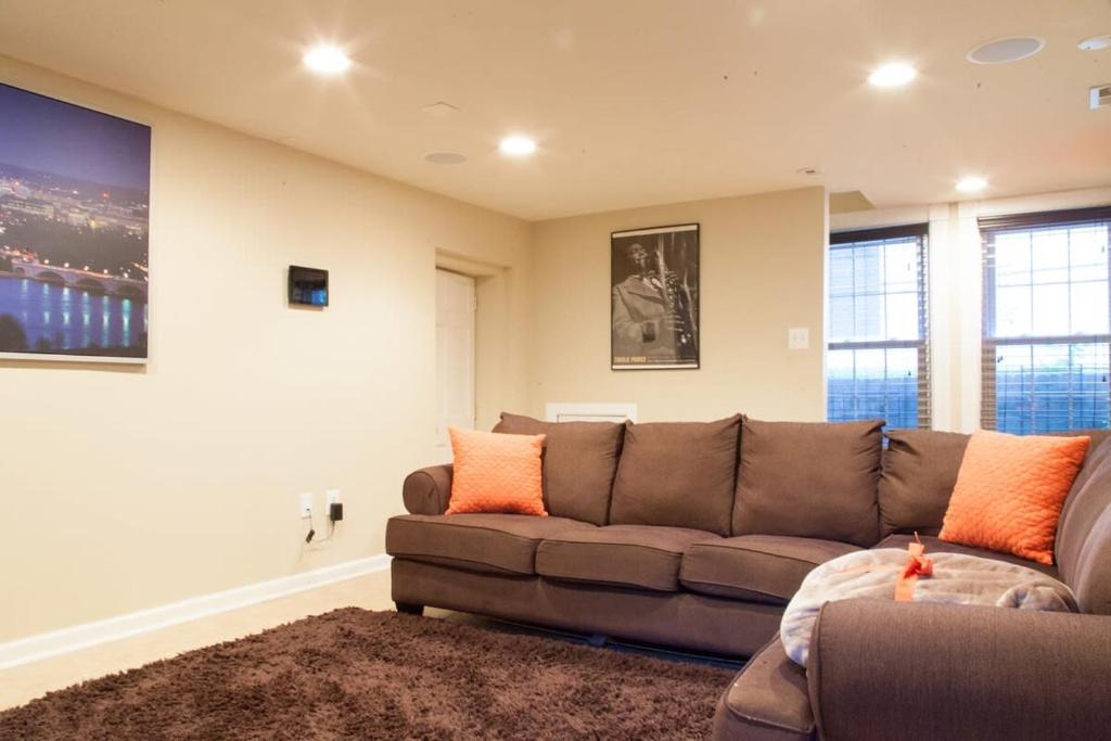 a living room with a brown couch and some windows at 1BR Oasis near Takoma Metro Minutes to Capital in Washington, D.C.