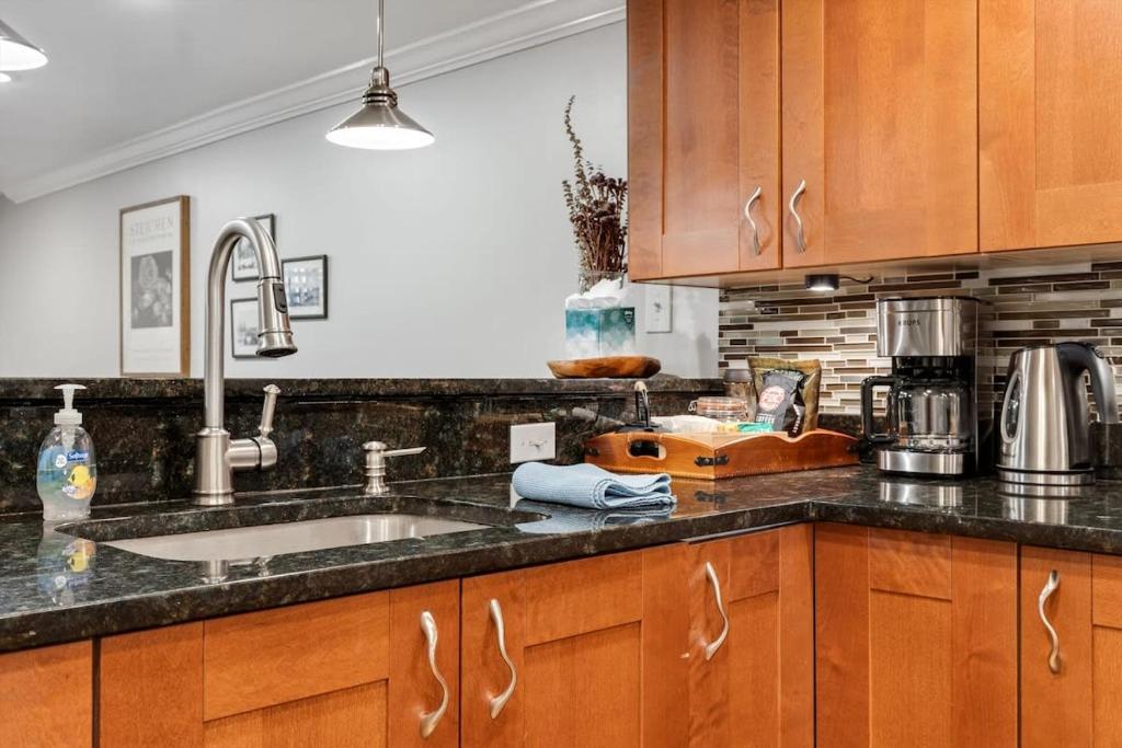 a kitchen with wooden cabinets and a sink at Entire 1-BR Apt in NoMa Eckington in Washington, D.C.
