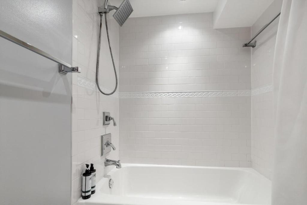 a white bathroom with a shower and a sink at Entire 1-BR Apt in NoMa Eckington in Washington, D.C.