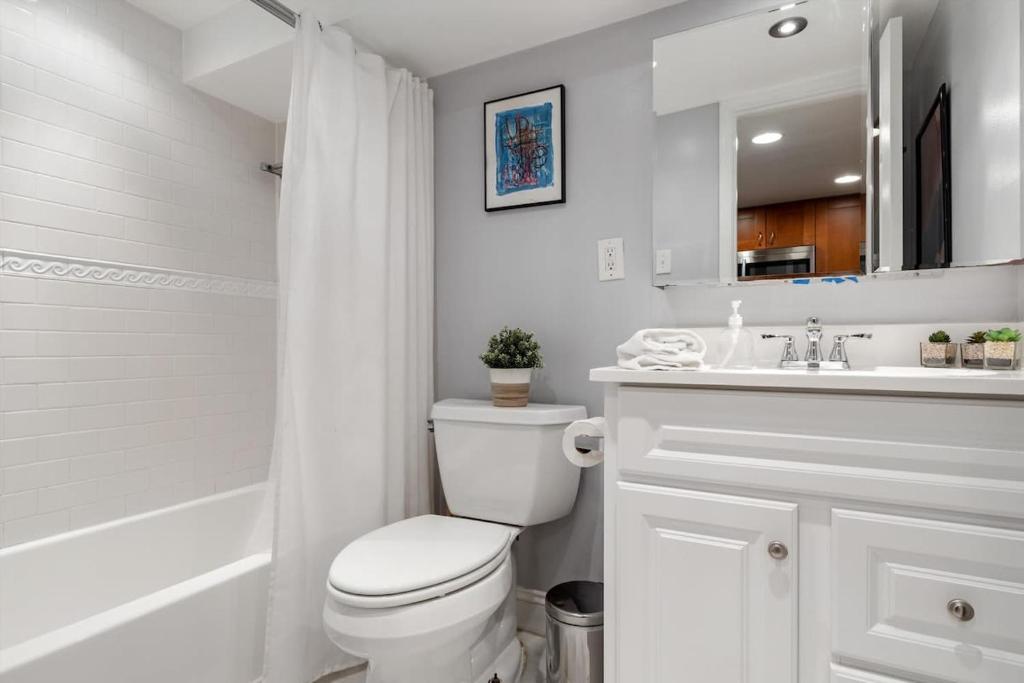 a white bathroom with a toilet and a sink at Entire 1-BR Apt in NoMa Eckington in Washington, D.C.