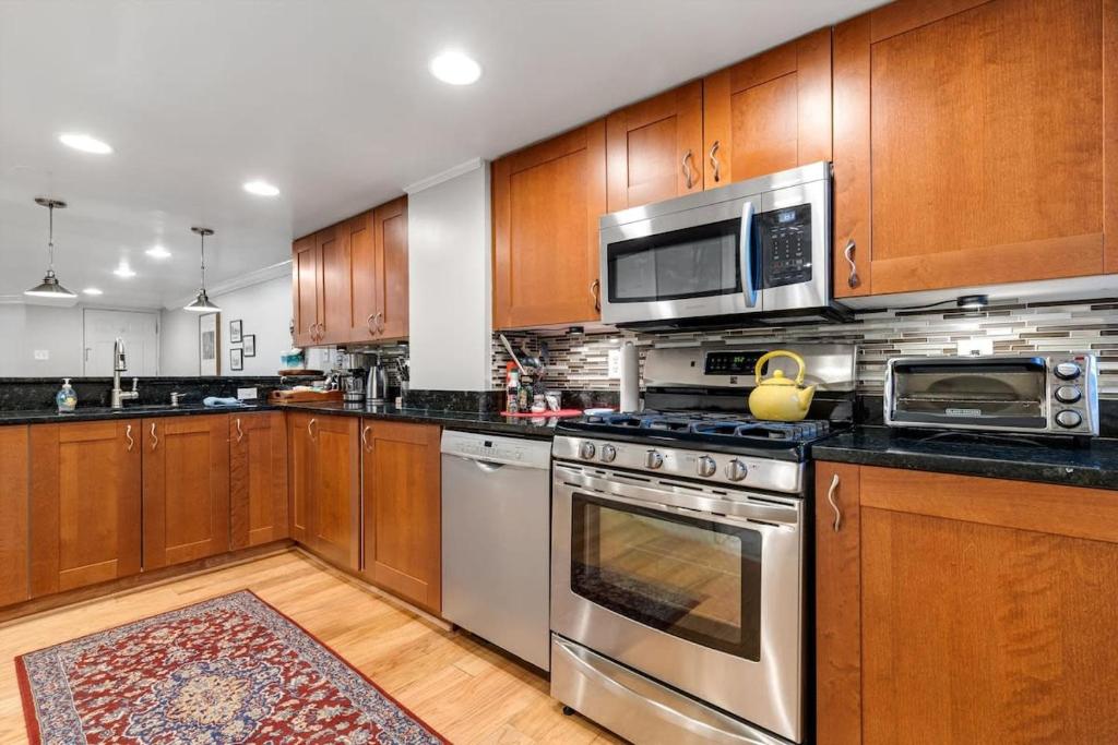 a kitchen with wooden cabinets and stainless steel appliances at Entire 1-BR Apt in NoMa Eckington in Washington, D.C.