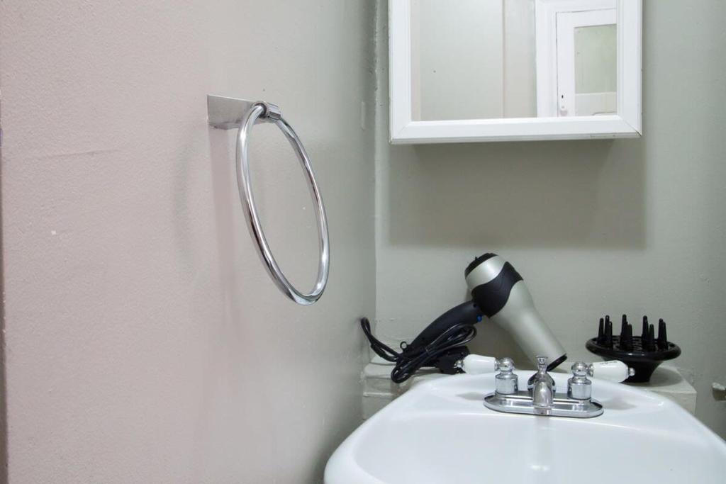a mirror on the wall above a bathroom sink at IDEAL GEORGETOWN STAY \ PARKING! \ W/D in Washington, D.C.