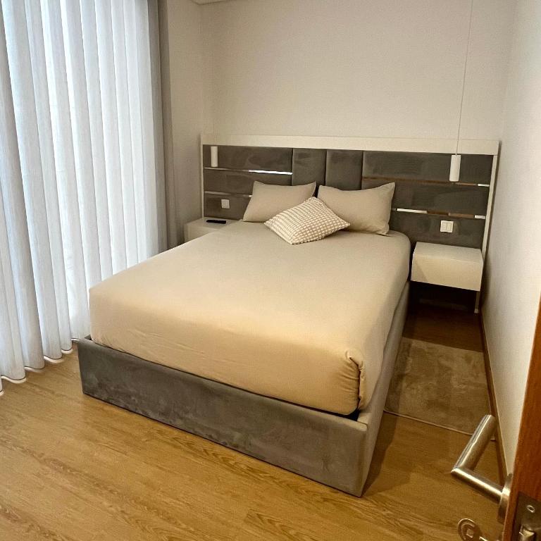 um quarto com uma cama grande e uma cabeceira. em Coruja’s House AL OPO no Porto