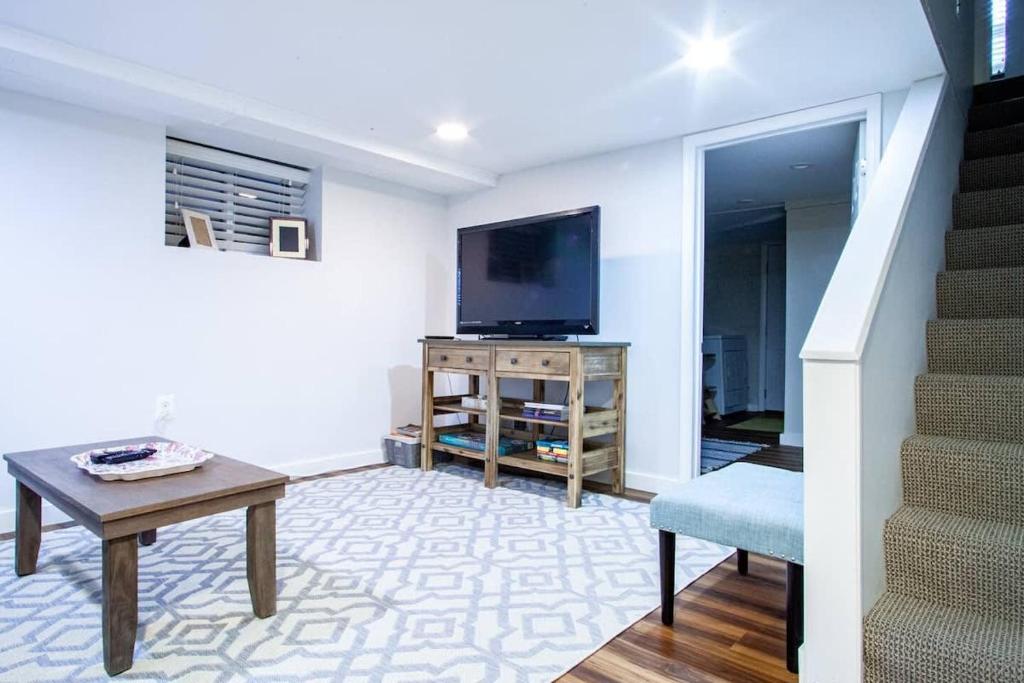a living room with a tv and a table and a chair at Transit-Friendly Home Old Town Parking in Alexandria