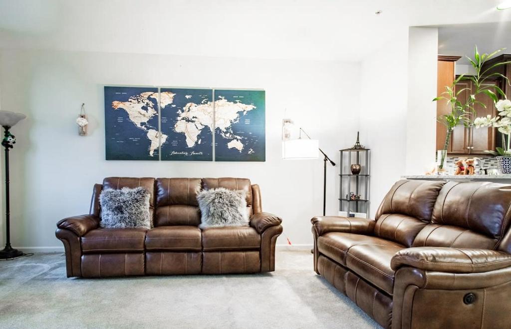a leather couch and a chair in a living room at Large MD Townhome mins to UMD & DC Parking in Greenbelt