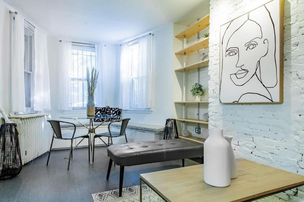 a living room with a table and chairs and a drawing on the wall at DesignerFlat Nestled Between Dupont&Logan Circles in Washington, D.C.