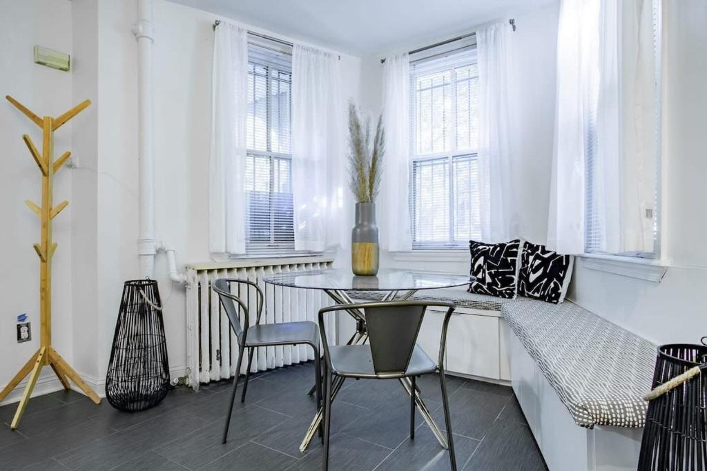 a dining room with a glass table and chairs at DesignerFlat Nestled Between Dupont&Logan Circles in Washington, D.C.