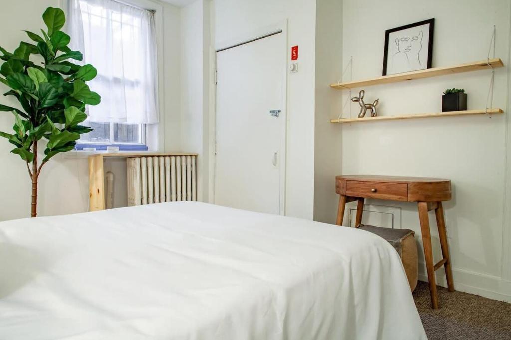 a bedroom with a white bed and a table at DesignerFlat Nestled Between Dupont&Logan Circles in Washington, D.C.