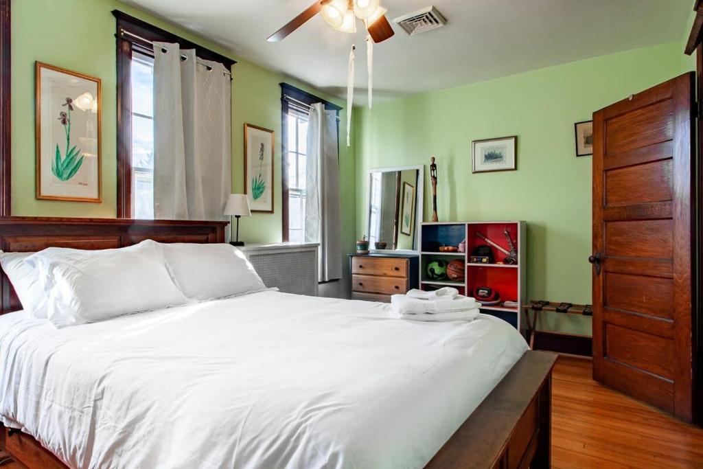 a bedroom with a large white bed with a ceiling fan at The E St Retreat Lovely 3-BR Nestled between H St & Eastern Market in Washington, D.C.