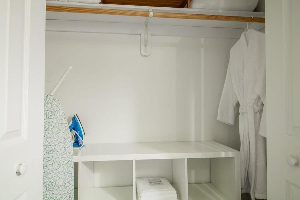 a white closet with a shelf and white clothes at DesignerFlat Nestled Between Dupont&Logan Circles in Washington, D.C.